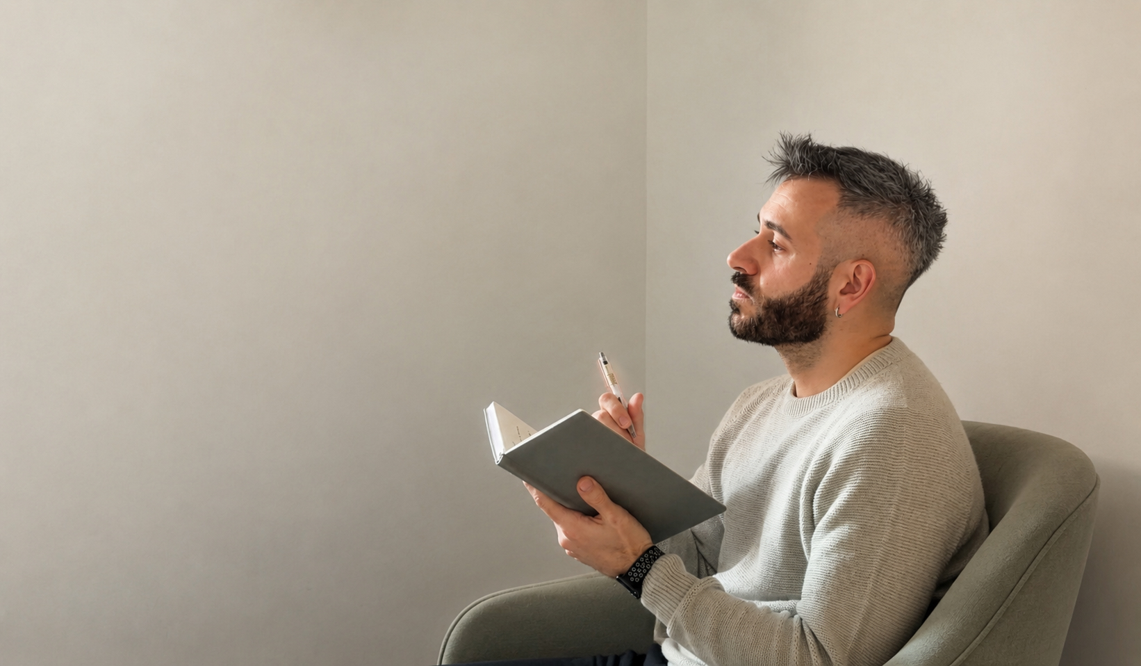 Jorge Grupeli en su espacio de consulta, sentado con un cuaderno